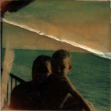  Homme avec enfant devant la mer, balustrade en arrière-plan. Image avec pliure.