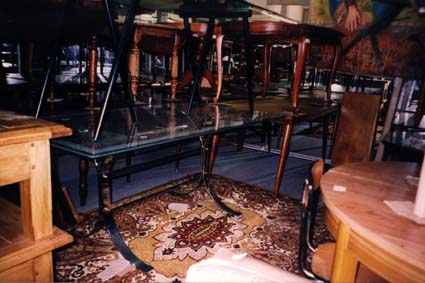  Table en verre où sont posées des chaises en bois.