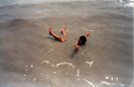  Baigneur avec bras et jambes sortis de la mer.