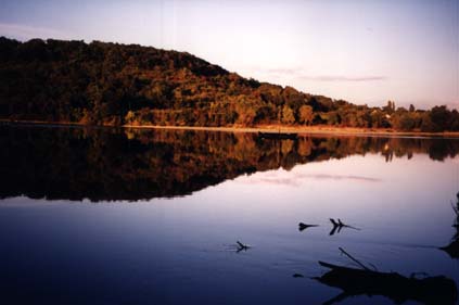  Étendue d'eau avec à sa surface le reflet d'une colline.
