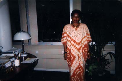  Femme africaine en boubou de tissu batik debout près d'un bureau.