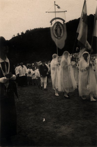 Femmes en voile blanc défilant avec une bannière religieuse à l'effigie de la Vierge. Photo ancienne sépia.ᴬᴵ