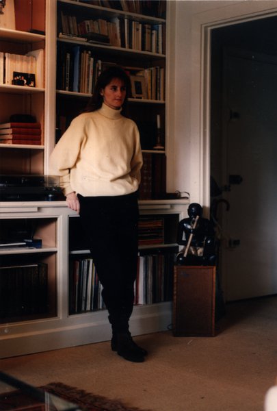 Femme debout appuyée contre une bibliothèque.ᴬᴵ